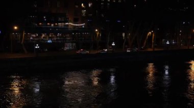 Nehir boyunca yoğun trafik yüzünden bulanık araba ışıkları. Gece şehir manzarası.