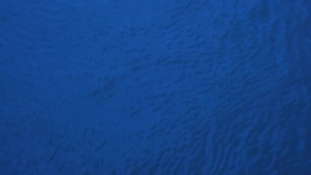 ダークブルーのトーニングで表面上の水の動きの抽象的な背景 — ストック動画