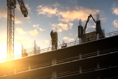 İşçiler beton dökmek için demirden bir kemer yapıyorlar. Şehirde yeni bir konut inşaatı.