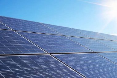 Şehir sokaklarını ve yolları aydınlatmak için güzel temiz bir gökyüzüne karşı elektrik üretimi için büyük endüstriyel güneş paneli.