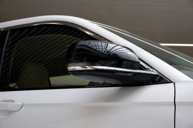 Bir araba galerisinde beyaz renkli modern bir off-road aracının dikiz aynası..