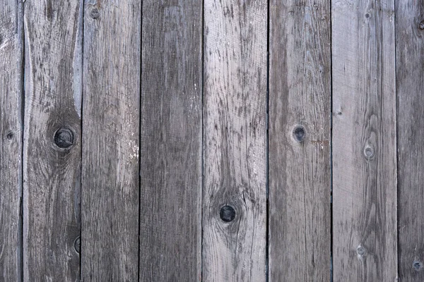 Close-up of a wooden board fence with time-faded boards and cracks. Template for design.