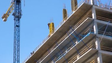 İşçiler beton dökmek için demirden bir kemer yapıyorlar. Şehirde yeni bir konut inşaatı