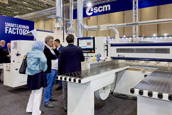 An engineer talks about the operation of woodworking equipment to a group of visitors at an exhibition WoodTech 2023 Woodworking Machinery Expo, Tuyap: Istanbul, Turkey - October 20, 2023.