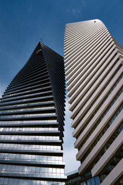 Bir temizlik şirketi, Chavchavadze Bulvarı 'ndaki güzel bir gökyüzünün arkaplanına karşı gökdelen Eksen Kuleleri' nde dikey görüntü sergiliyor. Endüstriyel dağcılık: Tiflis, Gürcistan - 19 Şubat 2023.