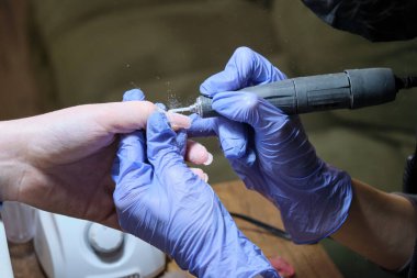 Manikür ustası manikürcüde çalışıyor. Makine işleme kesicisi.