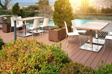 Güzel bir bahçede havuzun arka planında masaları olan bir yazlık kafe..