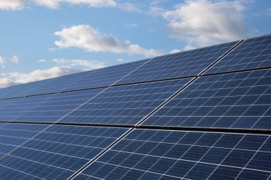 Şehir sokaklarını ve yolları aydınlatmak için elektrik üretimi için endüstriyel güneş paneli bulutlu güzel bir gökyüzünün arka planına karşı.