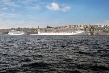 İki büyük deniz yolcu gemisi rıhtımda zemin üzerinde duruyor bulutlu güzel bir gökyüzü. Popüler deniz seyahatleri.
