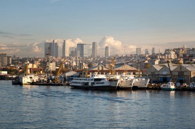 İstanbul, Türkiye - 19 Ekim 2023 tarihli İstanbul Boğazı, modern gökdelenlerin arkaplanına karşı kentin tarihi kesiminden liman ve set manzarası.