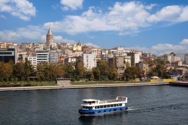 Şehrin tarihi kısmının deniz limanından Galata Kulesi ile güzel hava manzarası: İstanbul, Türkiye - 23 Ekim 2023