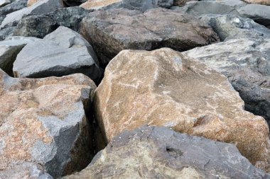 Deniz kıyısında büyük taşlar uzanıyordu. Fırtına seli koruması.