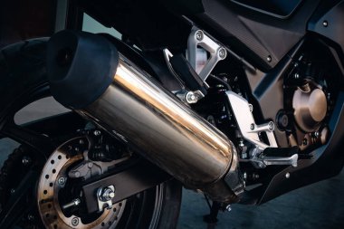 Çerçeve ve egzoz sistemli modern bir motosiklet motorunun yakın çekimi.