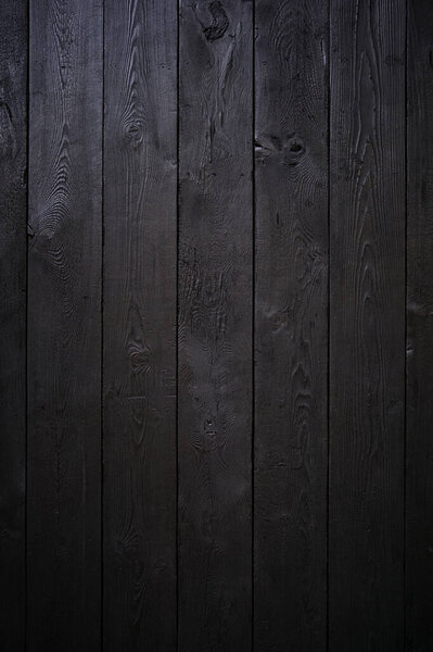 Vertical photo a beautiful wooden background made of boards painted black. Template for design.