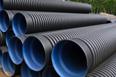Su temini için geniş plastik kıvrımlı borulara yakın çekim. Şehirdeki boru hattı ve kanalizasyonun yeniden inşası.