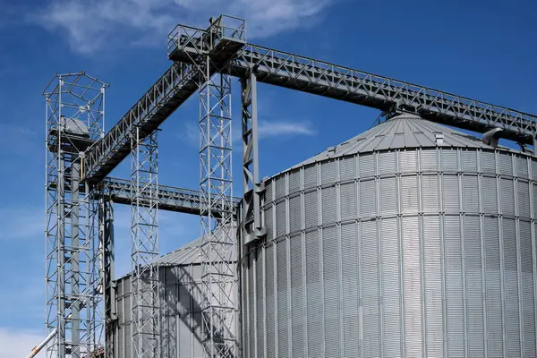 Industrial facilities of feed and flour mills. Close-up of steel grain storage silos with conical bottom, can be used for various purposes.