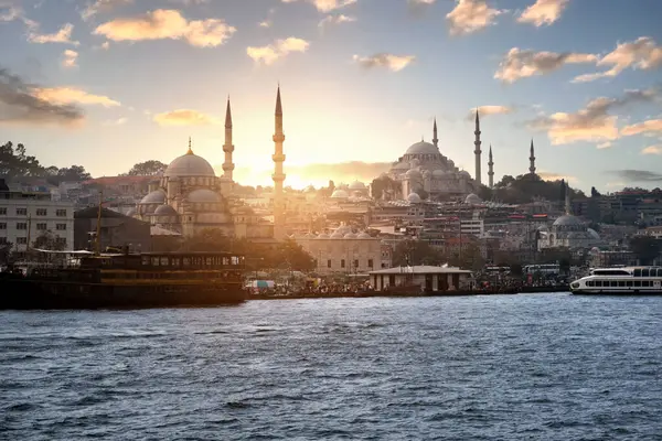İstanbul 'daki deniz manzarası, günbatımı gökyüzü ve caminin arka planına karşı..
