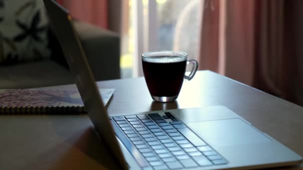 커피가있는 노트북과 노트북 옆에있는 가정용 부엌의 테이블에 있습니다 작업의 — 비디오