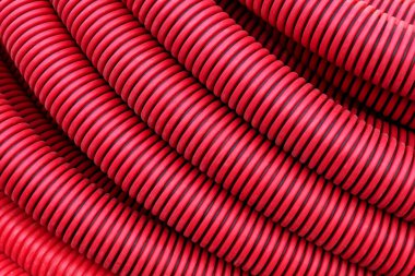 İletişim kurmak ve elektrik kablolarını yerleştirmek için kırmızı plastik bir boruya yakın plan. Modern inşaat teknolojileri.