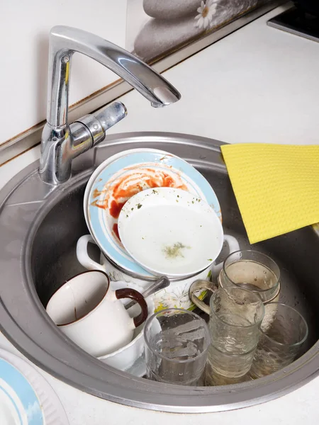 Top view of kitchen sink at home with dirty dishes. Work area in a home kitchen. Vertical image.