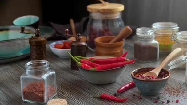 在一张漂亮的木制桌子上的玻璃瓶中 有大量的香料 辣椒和香料 在家里做调味品 全景运动 — 图库视频影像