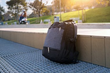 Şehir parkındaki kayıp ya da unutulmuş bir sırt çantası yeşil bir çimenliğin arka planına karşı.