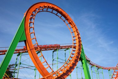 Lunapark trenine yakın çekim. Aşırı açık hava eğlencesi. Arkaplanda bulutlu güzel bir gökyüzü.