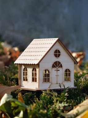 Sonbahar ormanındaki sarı yapraklı güzel bir oyuncak evin dikey görüntüsü. Seçici odak.