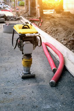 Manüel pnömatik trombus makinesi yolda duruyor. Kentsel altyapının onarımı ve yeniden inşası. Dikey resim.