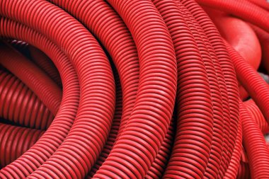 İletişim ve elektrik kablolarının kurulumu için kırmızı plastik boru. Modern inşaat teknolojileri.