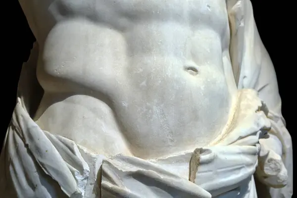 Close-up of a marble sculpture on a black background, depicting a man torso. Art and architecture of the ancient world.