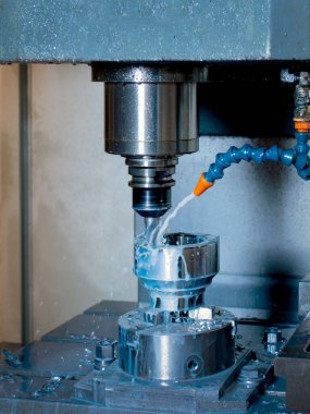 CNC 'de delik açan bir değirmen makinesinin yakın çekimi. Ağır sanayi için çelik parçaları üretimi.