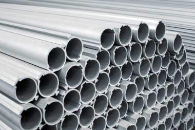 Bir makine fabrikasında bir sürü büyük alüminyum boru var. Ağır sanayi üretim süreci.