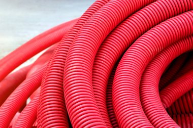 İletişim ve elektrik kablolarının kurulumu için kırmızı plastik boru. Modern inşaat teknolojileri.