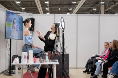 Antrenör yeni makyaj teknikleri üzerine bir master sınıfı yönetiyor. Güzellik endüstrisi sergisi 