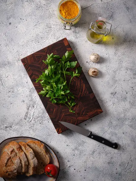 俯瞰一个漂亮的木制切菜板在餐桌背景与面包 蔬菜和香料 准备沙拉 免版税图库图片