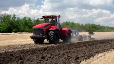 Tarlada sabanla çalışan büyük bir traktör. Hasattan sonra ekime başlayın. Tarımsal ekipman işi.