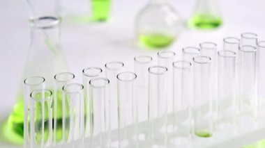 Laboratuvarda bir bilim adamı renkli bir sıvıyı test tüplerinde analiz etmek için pipet kullanır. Konsept: araştırma, biyokimya, doğa, ilaç.