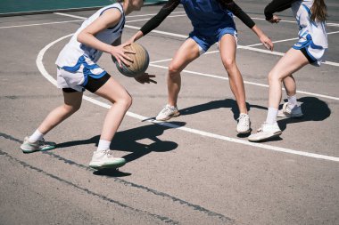 Genç kızlar şehirdeki bir sokak sahasında sokak basketbolu oynuyorlar. Gençler arasında aktif eğlence ve eğlence.