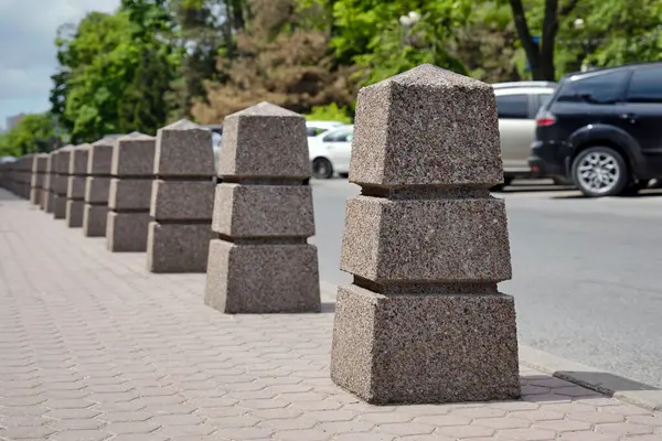 stock image Close-up of a lot of restrictive granit stone bollards on the street in the city. The concept of safe car traffic. 