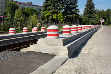 Şehirdeki demiryolu yolunda bir sürü kısıtlayıcı taş var. Güvenli araba ve demiryolu trafiği kavramı.