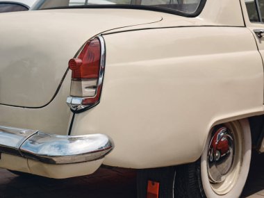 Güzel, bej rengi klasik bir arabanın arka tarafında. Şehir caddesinde 60 'lardan kalma eski arabaların sergisi.