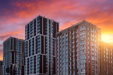 Güzel bir günbatımı gökyüzüne karşı ilginç bir tasarıma sahip yeni bir yerleşim yeri inşa etmek için yakın plan..