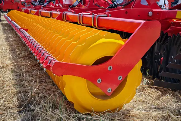 stock image Close-up of a large modern plow yellow color or disc harrow for cultivating the land. New model of agricultural equipment. Selective focus.