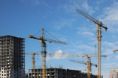 Yeni bir modern konut kompleksinin inşası başlıyor. İnşaatın başlangıcında birkaç yerleşim yeri ve güzel bir gökyüzünün arka planına karşı yüksek binalar..