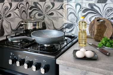 Evde çırpılmış yumurta pişirmeye hazırlanıyorum. Ev mutfağının masasında boş tava yumurtası, bitki ve tereyağı var..