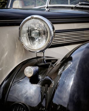 30 'lu yılların ortalarında güzel bir klasik arabanın ön tarafında. Şehir parkında restore edilen eski arabaların sergisi.