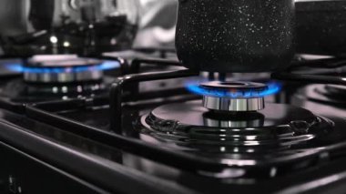 Ev mutfağındaki ocakta gaz ocakları yanıyor, yemek pişiriliyor..