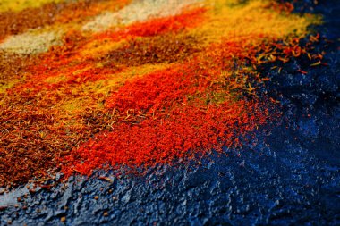 Pek çok farklı rengarenk doğal baharatların yakın çekimi. Kafe ve restoran menülerinin tasarımı için soyut bir arka plan. Seçici odak.