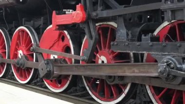 Tren istasyonundaki buharlı lokomotif tekerleklerinin yan görüntüsü. Tren müzesinde çalışıyorum. Panoramik hareket.